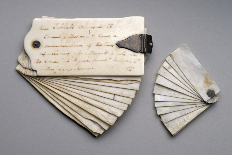 Two historic examples of complete aide-memoire booklets with no covers, fanned out to display the layers. The booklet on the left has at least twelve pages and script written on the exterior page. The booklet on the right is much smaller and has at least 10 pages.